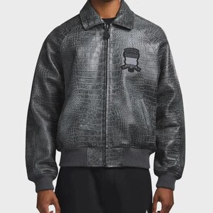 May include: A charcoal gray zip-up jacket featuring a textured crocodile skin pattern throughout. The garment includes a classic collar, ribbed cuffs and hem, and a black embroidered patch on the left chest with the text Supreme New York.