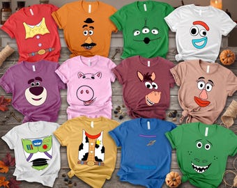 May include: A collection of twelve short-sleeved t-shirts in various colors, each featuring a graphic print inspired by Toy Story characters, including faces of Mr. Potato Head, an alien, Forky, Lotso, Hamm, Bullseye, Mrs. Potato Head, and Rex.