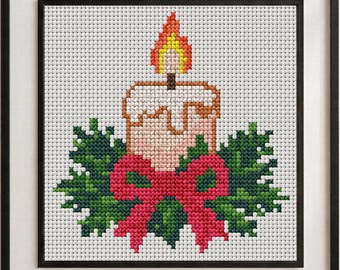 May include: A framed cross-stitch embroidery featuring a central candle with a yellow and orange flame, surrounded by green holly leaves and a bright red bow, all set against a white grid fabric background within a simple black frame.