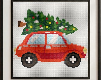 May include: A framed cross-stitch embroidery featuring a bright red car carrying a green Christmas tree on its roof. The car has light blue windows, dark brown wheels with white centers, and yellow headlights, all set against a white grid.