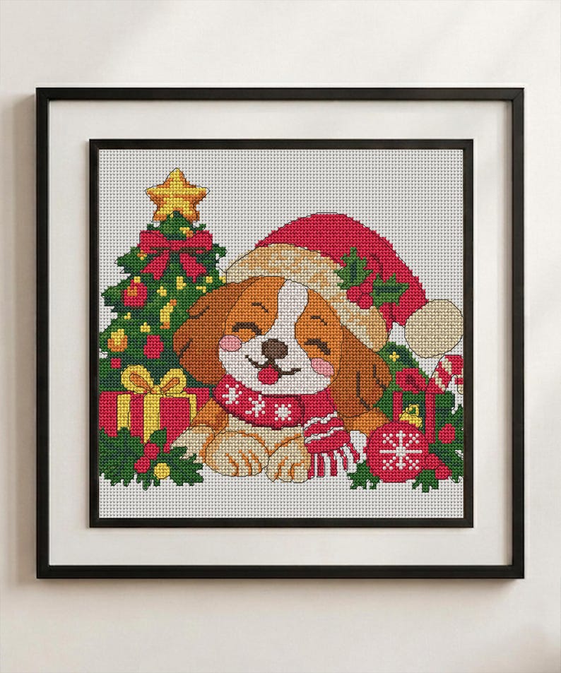 May include: A framed cross-stitch pattern featuring a brown and white puppy wearing a red Santa hat and a red and white scarf. The puppy is surrounded by a decorated Christmas tree, wrapped gifts, holly leaves, and a red ornament with a snowflake.