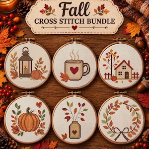 May include: A set of six circular wooden embroidery hoops containing cross stitch patterns with autumn themes, including a lantern, a mug, a house, a pumpkin, a vase, and a wreath. A sign above reads Fall CROSS STITCH BUNDLE.