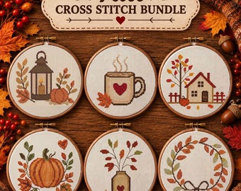 May include: A set of six circular wooden embroidery hoops containing cross stitch patterns with autumn themes, including a lantern, a mug, a house, a pumpkin, a vase, and a wreath. A sign above reads Fall CROSS STITCH BUNDLE.