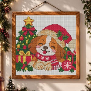 May include: A framed cross-stitch embroidery featuring a brown and white puppy wearing a red Santa hat and a red scarf with white snowflake patterns. The puppy is positioned next to a decorated Christmas tree, red gift boxes, and a red ornament.
