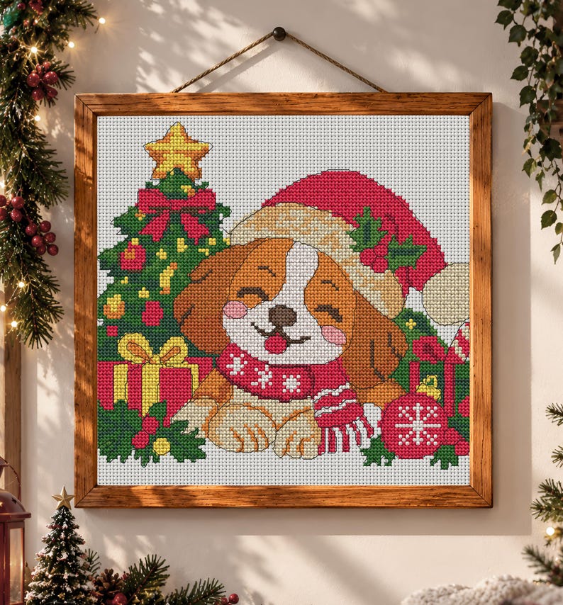 May include: A framed cross-stitch embroidery featuring a brown and white puppy wearing a red Santa hat and a red scarf with white snowflake patterns. The puppy is positioned next to a decorated Christmas tree, red gift boxes, and a red ornament.
