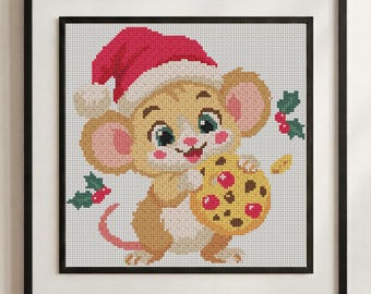 May include: A framed cross-stitch embroidery featuring a light brown mouse with large ears and pink cheeks wearing a red and white Santa hat. The mouse is holding a yellow cookie with red and brown spots, surrounded by small green holly leaves with red berries.