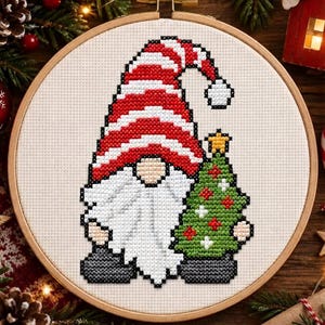 May include: A cross-stitch pattern in a wooden embroidery hoop featuring a gnome with a long white beard, wearing a red and white striped hat with a white pom-pom, standing next to a green Christmas tree decorated with red and white ornaments.