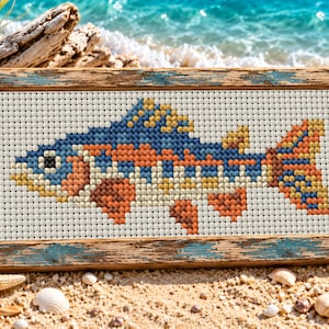 May include: A rectangular cross-stitch embroidery featuring a stylized fish with a mosaic pattern of blue, orange, yellow, and white threads. The artwork is encased in a weathered, rustic wooden frame with visible blue paint accents.