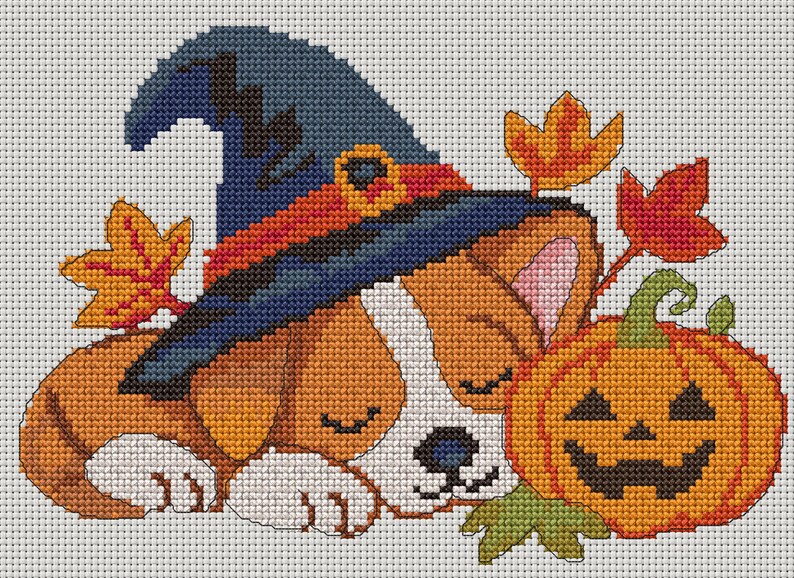 May include: A cross-stitch pattern featuring a sleeping puppy wearing a dark blue witch hat with an orange band. The puppy is positioned next to a carved orange jack-o'-lantern pumpkin and several scattered autumn leaves in shades of yellow and red.