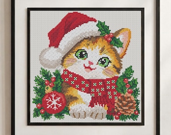 May include: A framed cross-stitch embroidery featuring a ginger and white kitten wearing a red Santa hat and a red scarf with white patterns. The kitten is surrounded by green holly leaves, red berries, a red Christmas ornament, and a pinecone.