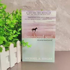 May include: A hardcover book titled "the untethered soul" by Michael A. Singer. The cover features a silhouette of a horse on a beach. Text includes "#1 New York Times Bestseller" and a quote by Deepak Chopra.