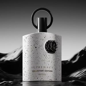 Puede incluir: Un frasco de perfume blanco y negro moteado con un asa de anillo negro. El frasco tiene un emblema negro y las palabras "SUPREMACY COLLECTOR'S EDITION AFNAN" impresas en la parte delantera. El fondo es una imagen en escala de grises de olas.