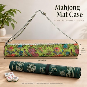 May include: A cylindrical quilted Mahjong Mat Case with a green floral and peacock print, featuring a black and white striped shoulder strap. It measures 33 inches in length and 6 inches in diameter. A rolled dark green mat and tiles are shown.