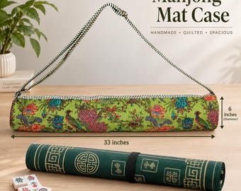 May include: A cylindrical quilted Mahjong Mat Case with a green floral and peacock print, featuring a black and white striped shoulder strap. It measures 33 inches in length and 6 inches in diameter. A rolled dark green mat and tiles are shown.