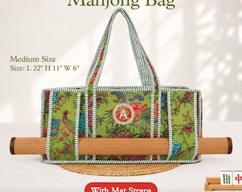 May include: A green fabric bag with a floral and bird pattern, featuring a central letter A monogram, striped handles, and integrated straps holding a rolled bamboo mat. The bag measures 22 inches long, 11 inches high, and 6 inches wide.