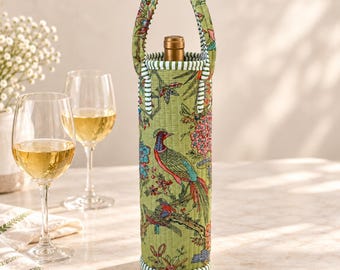 May include: A quilted fabric wine bottle carrier in a light green hue, featuring a colorful print of birds and floral patterns. The cylindrical bag has two matching handles and a green and white striped trim along the top and bottom edges.