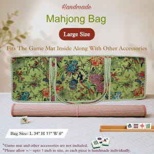 May include: A large green rectangular Mahjong bag featuring a floral and bird pattern with a central letter A monogram. The bag includes two handles and measures 34 inches long, 11 inches high, and 6 inches wide. A rolled mat and tiles are shown.
