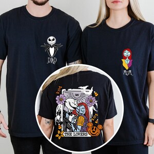 May include: Two black t-shirts featuring chest graphics of Jack Skellington labeled DAD and Sally labeled MUM. A circular inset shows the back of a black t-shirt with a tarot card graphic of Jack and Sally titled THE LOVERS with pumpkins.