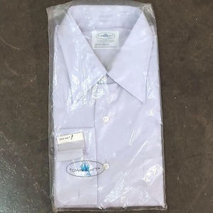 Op de afbeelding: Een wit overhemd met lange mouwen en een knoopsluiting. Het shirt heeft een klein label aan de voorkant met de tekst "Towncraft" en een klein label aan de onderkant met de tekst "Super Non-Iron".