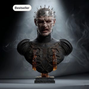 Può includere: Busto dettagliato di un personaggio con una griglia metallica sulla testa e spilli. La figura ha un'espressione severa e indossa un abito scuro e ornato. Il busto è su una base decorativa, con un'etichetta "Bestseller".