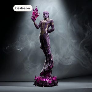 Op de afbeelding: Een paars en goud beeldje van een humanoïde figuur die een gloeiend roze object vasthoudt. De figuur staat op een gedetailleerde, donkerpaarse basis met roze accenten. Het woord "Bestseller" staat in een witte ovaal linksboven.