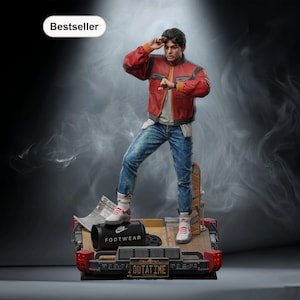 Può includere: Statuetta dettagliata di un personaggio di un film di fantascienza, con giacca rossa, jeans blu e scarpe da ginnastica bianche. La statuetta è su un cassone con la targa "OUTATIME". Un'etichetta "Bestseller" è in alto a sinistra.