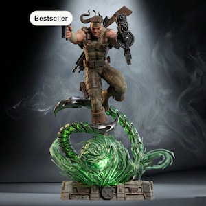 Op de afbeelding: Gedetailleerd beeldje van een gespierd personage in gevechtsuitrusting, met twee geweren. Het figuur staat dynamisch op een groene, gloeiende, gestileerde basis. Het woord "Bestseller" staat in een witte ovaal.