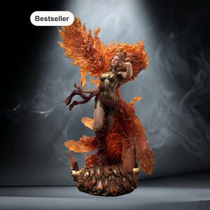 May include: A detailed statue of a woman in a gold bodysuit, surrounded by fiery orange and red wings and flowing elements. The base is adorned with brown gems. The word "Bestseller" is in a white box in the upper left corner.