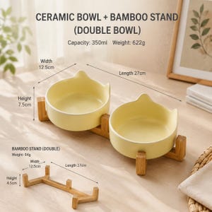 May include: Two pale yellow ceramic bowls with cat-ear shaped rims set on a bamboo stand. Text indicates a 350ml capacity and 622g weight. A separate bamboo stand is shown with dimensions of 12.5cm width, 27cm length, and 4.5cm height.