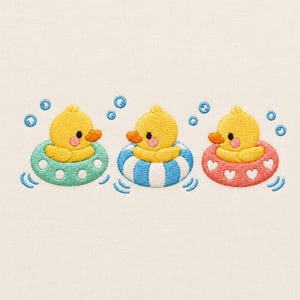 May include: An embroidery design featuring three yellow ducklings with orange beaks and pink cheeks. Each duckling floats in a different inner tube: one mint green with white dots, one blue and white striped, and one coral pink with white hearts.