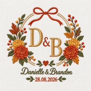 Op de afbeelding: Een borduurontwerp met een krans van herfstbladeren, bessen en chrysanten in oranje, geel en groen. In het midden staan de gouden letters D & B, een rode strik, een klein hartje en de tekst Danielle & Brandon met de datum 28.08.2026.