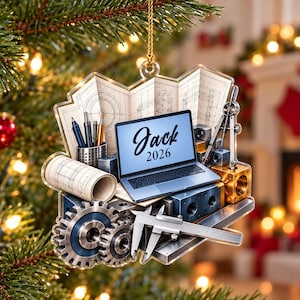 May include: A clear acrylic ornament featuring a laptop with the text Jack 2026 on the screen, surrounded by engineering tools including a compass, calipers, gears, a rolled blueprint, and a pen holder with pens, all suspended by a gold cord.
