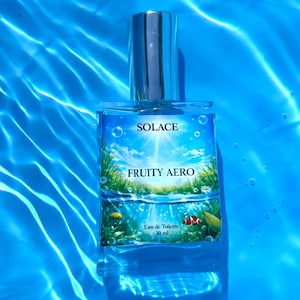 Puede incluir: Un frasco de perfume rectangular de cristal con tap&oacute;n plateado, etiquetado como Solace Fruity Aero Eau de Toilette 30 ml. La etiqueta muestra un cielo brillante, hierba verde e im&aacute;genes submarinas con peces sobre un fondo de agua azul.