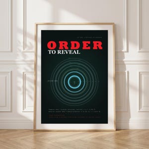 May include: A framed poster with a black background and a concentric circle design in shades of blue and green. The words "ORDER TO REVEAL" are in large red letters at the top. The poster has a wooden frame.