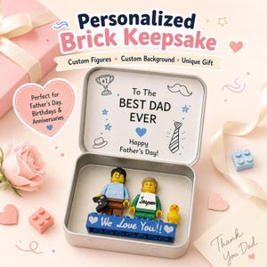 May include: A personalized brick keepsake in a silver tin, featuring custom Lego figures and text that reads "To The Best Dad Ever" and "We Love You!!". The image includes a pink gift box, a rose, and heart-shaped decorations.