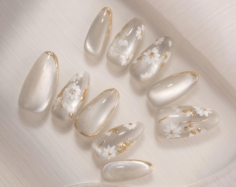 Romig witte pers op de nagels, medium amandel met gouden accenten