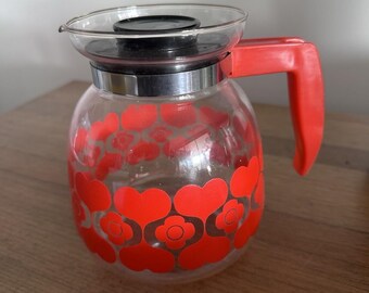 Caffettiera vintage con design floreale e fiore rosso
