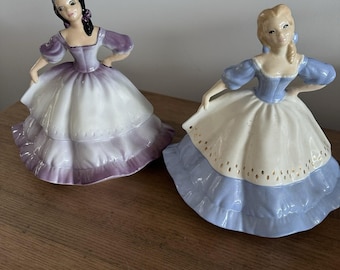 2 statuette in ceramica e porcellana raffiguranti donne, viola/bianco e blu/bianco.