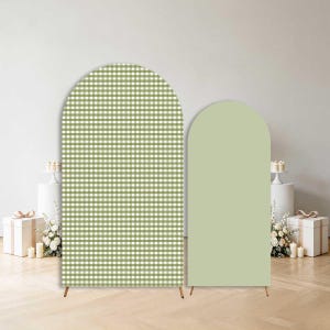 May include: Two arched backdrop stands featuring a rounded top design. The larger stand displays a sage green and white gingham check pattern, while the smaller stand is a solid, matte sage green color. Both are supported by thin metal legs.
