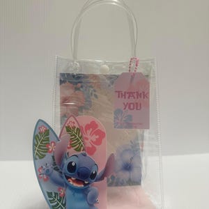 May include: Clear plastic gift bag with a blue cartoon character holding a surfboard. The bag has a pink tag that says "THANK YOU". The background has a floral design with pink and blue flowers.