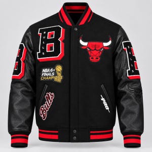 Puede incluir: Una chaqueta universitaria negra con cuello, puños y dobladillo acanalados a rayas rojas y negras. El frente presenta una letra B grande, un logotipo de los Chicago Bulls, un parche de NBA 6x Finals Champions y la palabra Bulls en cursiva con el texto PRO.