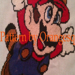 May include: Cross-stitch artwork of a red and blue Super Mario character with a brown hat and mustache. The character is jumping and has a white glove on one hand. The text "Pattern by Orangesq" is visible at the bottom of the image.