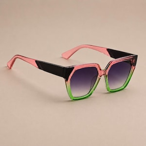 Peut inclure: Lunettes de soleil géométriques avec un dégradé de couleurs. Les montures passent du rose au vert, avec des détails noirs et des verres dégradés. Les branches sont roses. Ces lunettes offrent un look moderne et tendance.