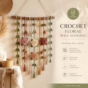 Può includere: Un arazzo floreale all'uncinetto fatto a mano. L'arredamento murale presenta un'asta di legno con fili di filo sospesi, adornati con rose, foglie e nappe all'uncinetto. La tavolozza dei colori comprende crema, rosa e verde. Il testo sull'immagine dice "CROCHET FLORAL WALL HANGING".