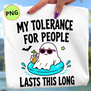 Peut inclure: Un t-shirt blanc avec un motif représentant un fantôme blanc portant des lunettes de soleil roses, flottant dans une bouée bleu vif tout en tenant une boisson avec un petit parasol. Le texte indique MY TOLERANCE FOR PEOPLE LASTS THIS LONG.