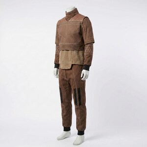 May include: A brown two-piece outfit consisting of a short-sleeved top with a high collar and matching trousers. The top features a layered design with light-colored stitching, while the trousers include dark vertical panels and reinforced seams.