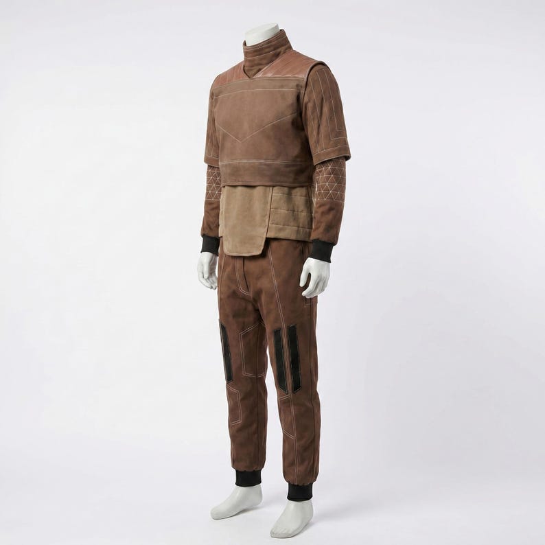May include: A brown two-piece outfit consisting of a short-sleeved top with a high collar and matching trousers. The top features a layered design with light-colored stitching, while the trousers include dark vertical panels and reinforced seams.