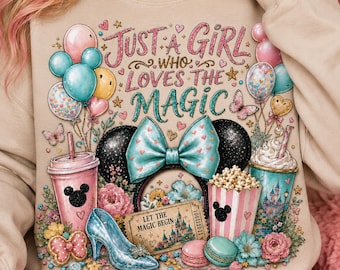May include: A beige crewneck sweatshirt featuring a colorful graphic print with the text "JUST A GIRL WHO LOVES THE MAGIC". The design includes balloons, a pair of mouse ears with a bow, a glass slipper, popcorn, a drink cup, and a ticket.
