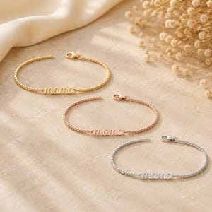 May include: Three delicate box chain bracelets, each featuring the word mama in a cursive script. The set includes one gold-tone, one rose gold-tone, and one silver-tone bracelet, all equipped with a small lobster claw clasp for secure fastening.