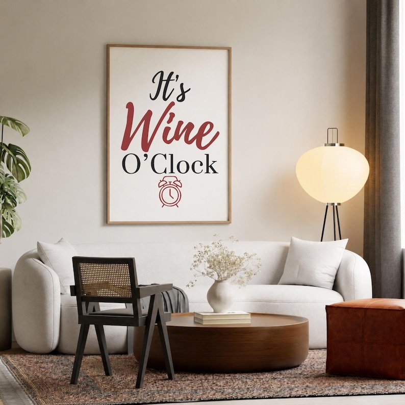 May include: A rectangular wall art print in a light wood frame featuring the black and red text It's Wine O'Clock with a small red alarm clock icon centered below the text, displayed against a plain off-white wall background.